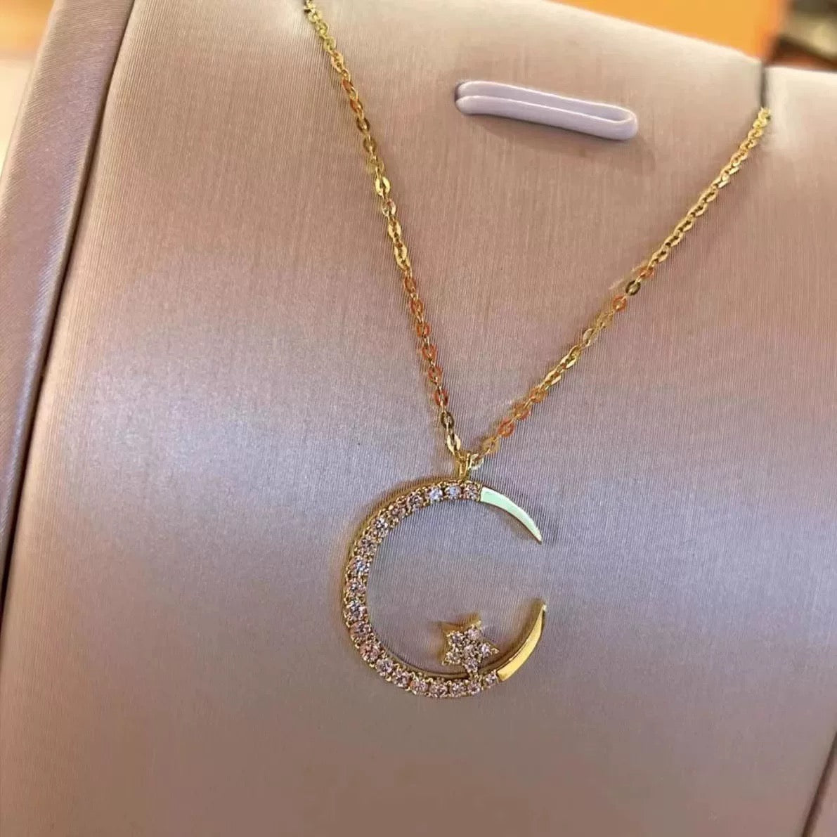 Close-up photo of Star and Moon Necklace showing star and moon pendant details